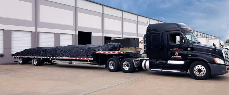 Texas Top Notch Trucking black truck with flatbed load